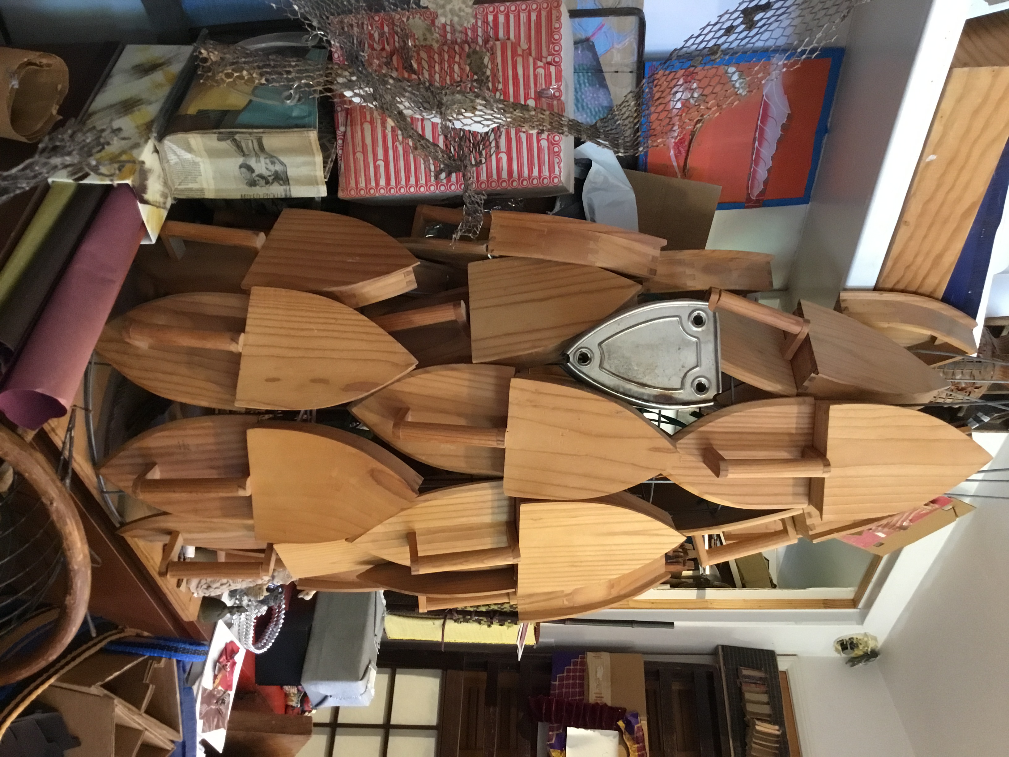 This structure was made with opened, wooden iron boxes from Mexico. The flat, metal object would be used to hold a hot iron. These are attached to two metal tomato cages.